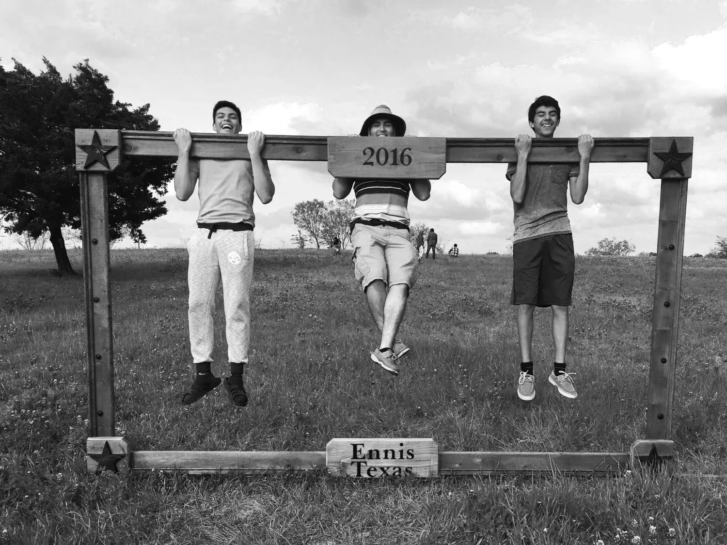 Claudio Romero and friends hanging from the Ennis, Texas 2016 photo frame at Bluebonnet Park